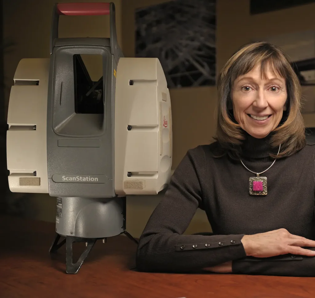 CEO of Darling Environmental, Mary Darling, wearing a black long sleeve shirt sitting next to drone.
