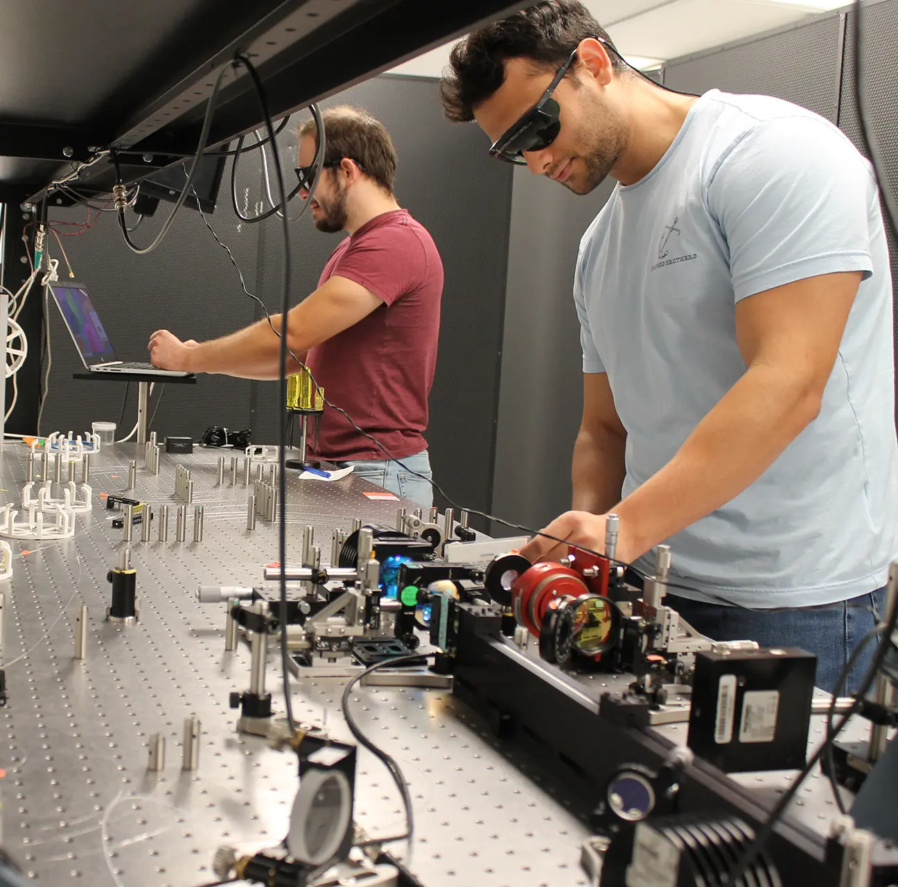 Two engineers at Applied Energetics work on ultrashort pulse optical sources.