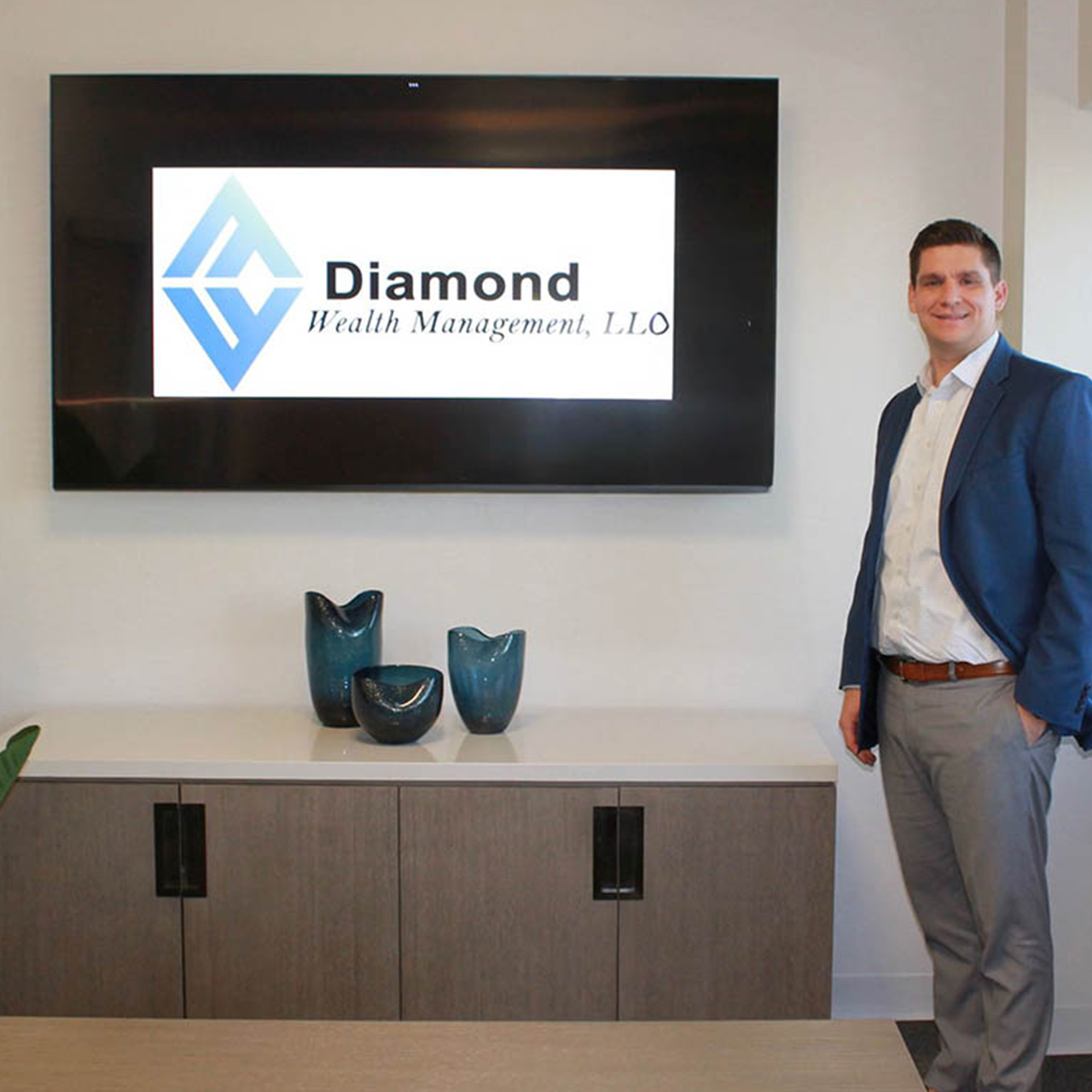 Diamond Wealth CEO standing next to logo on TV