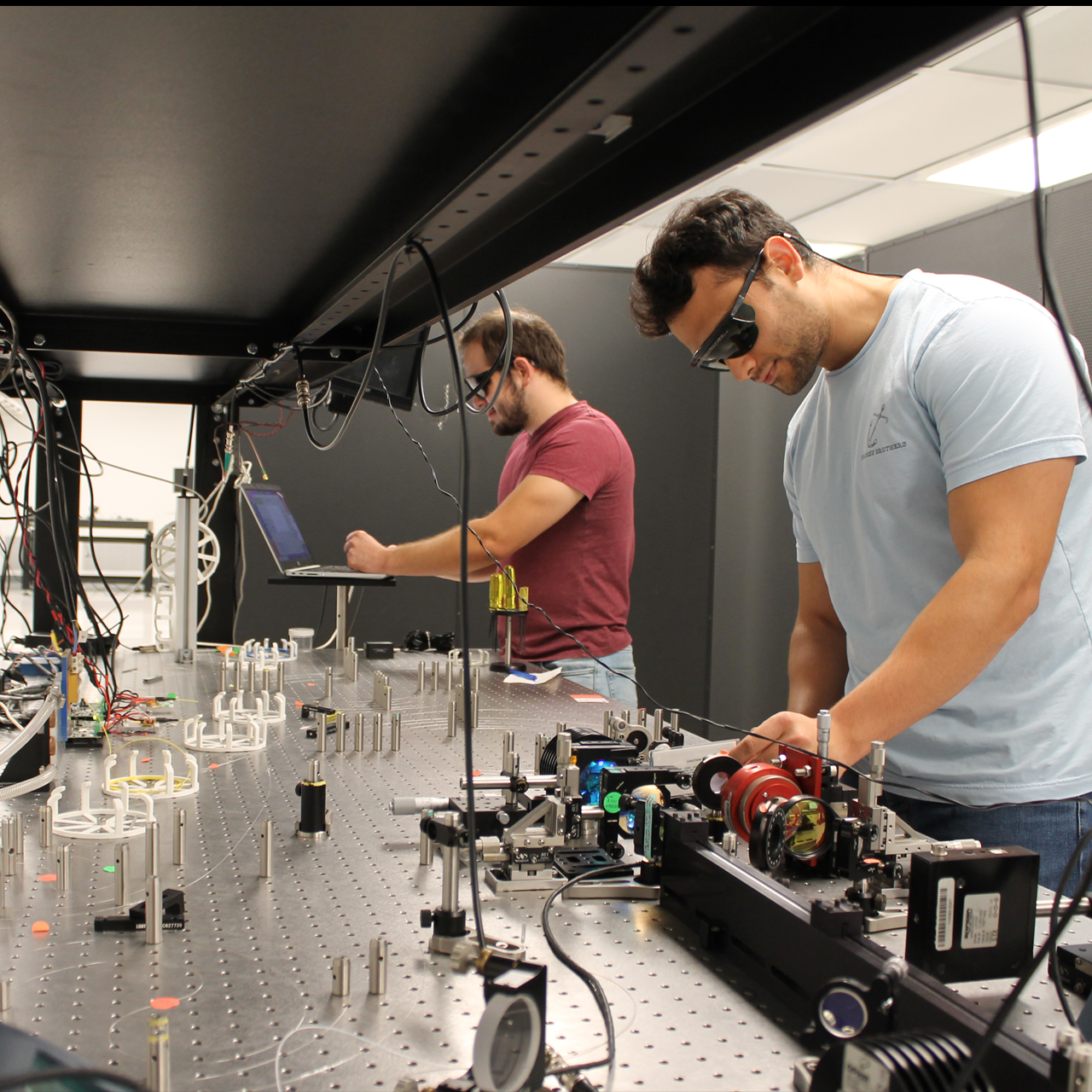 Two engineers at Applied Energetics work on ultrashort pulse optical sources.