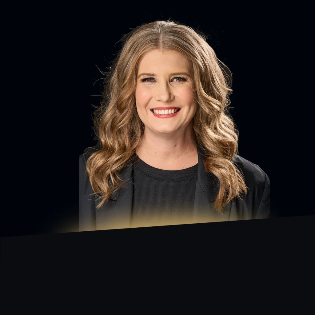 Headshot of Nicola Esposito wearing a black blazer with gold glow at the bottom