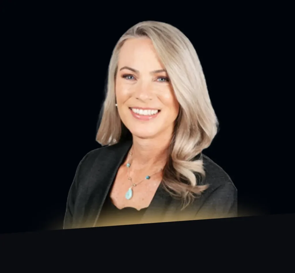 Stacey Lemos headshot wearing black blazer with gold glow at bottom of photo