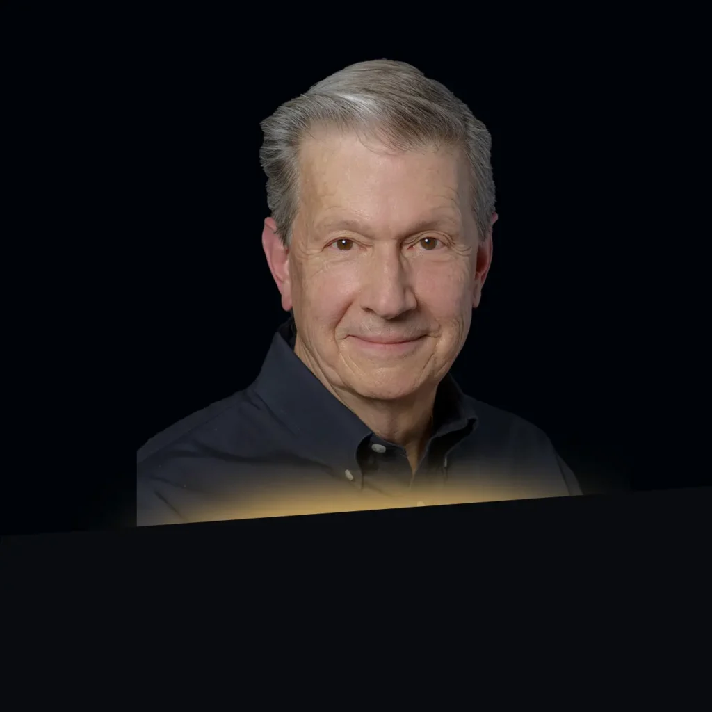 Steven Wood headshot wearing a black button down with gold glow at the bottom