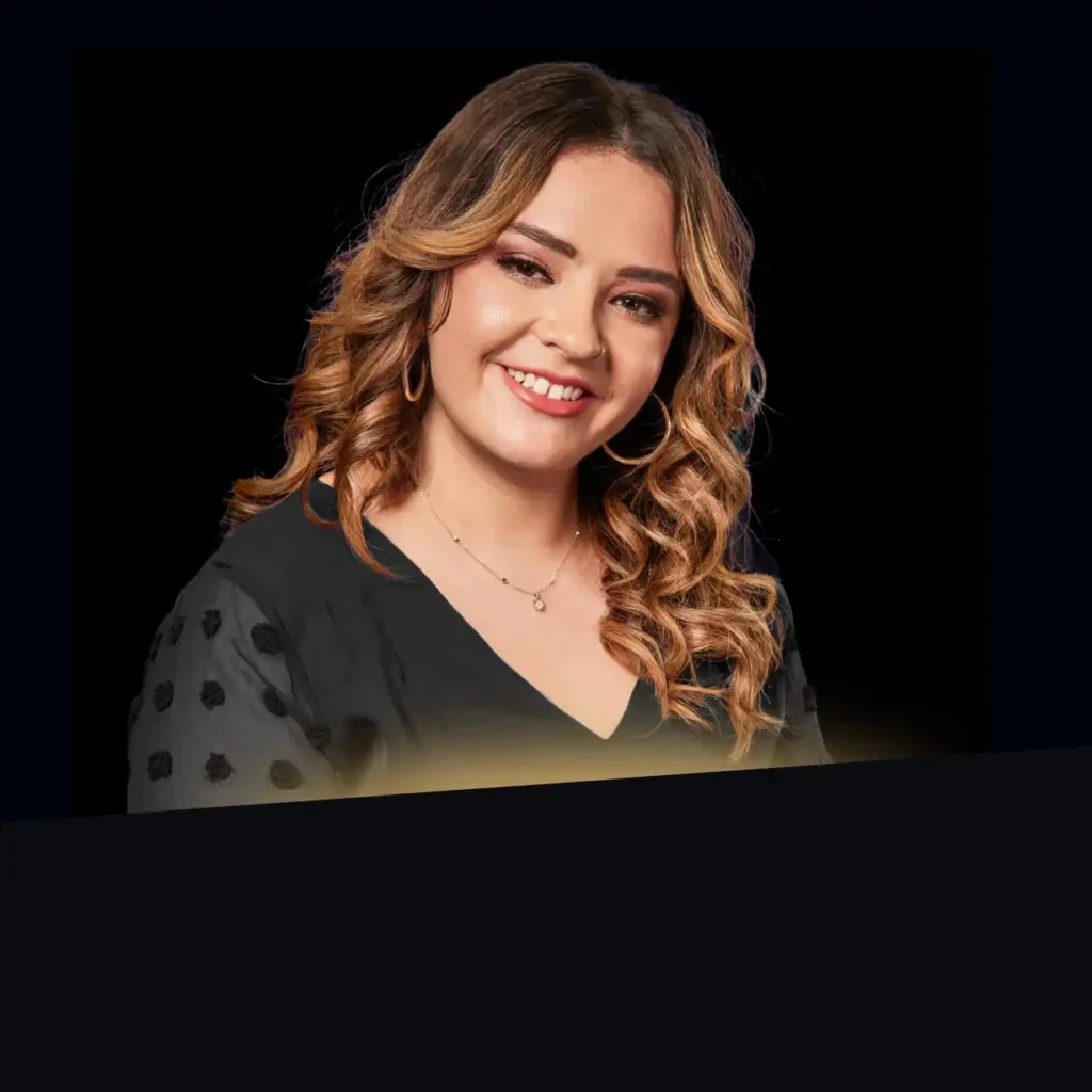 Headshot of Casey Carrillo wearing a black blazer with gold glow at the bottom