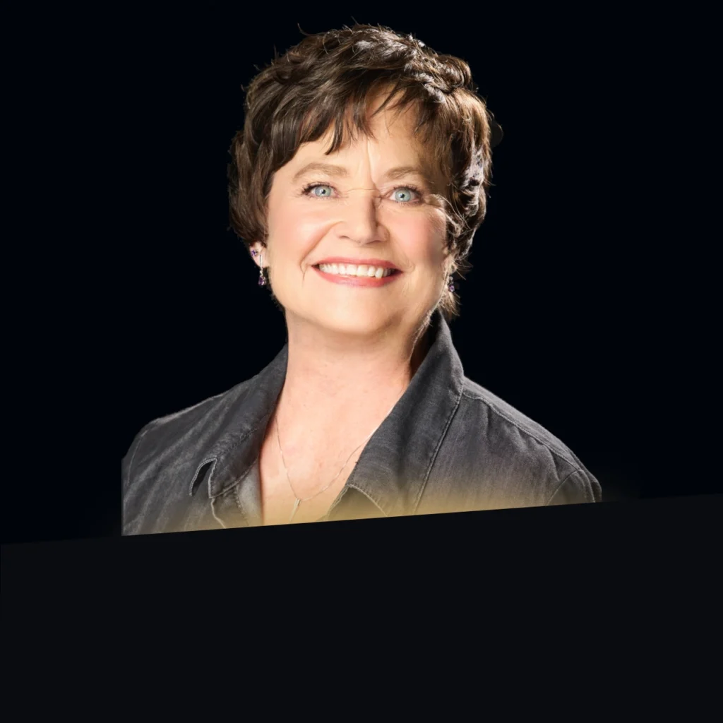 Headshot of Beth Megerle wearing a black blazer with gold glow at the bottom