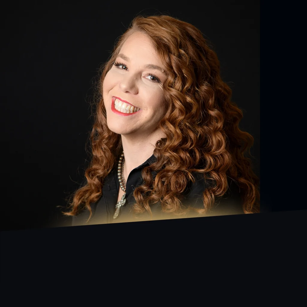 Headshot of Jessa Turner wearing a black blazer with gold glow at the bottom