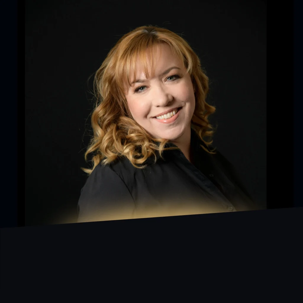 Headshot of Kat Martinez wearing a black blazer with gold glow at the bottom