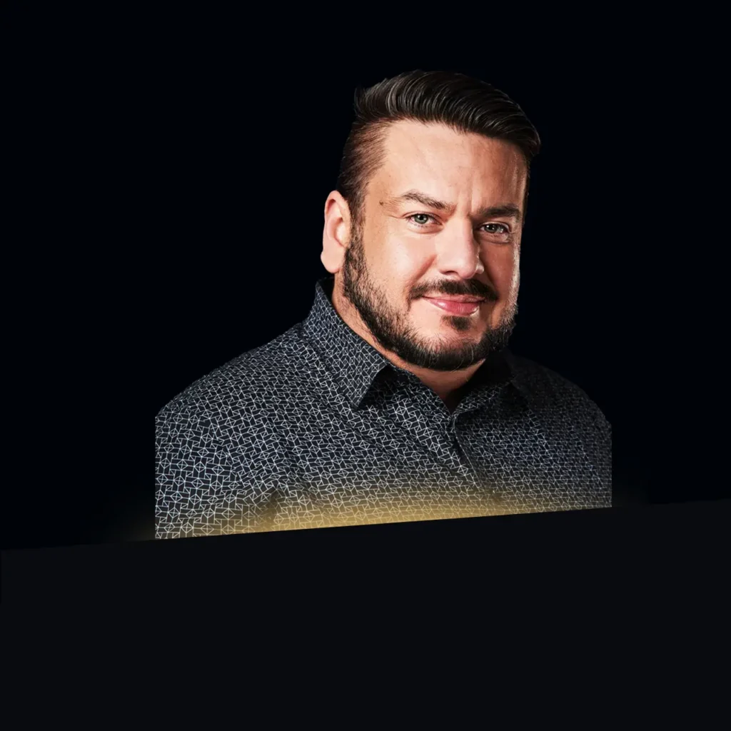 Peter Loya headshot wearing dark blue patterned shirt with gold glow at the bottom