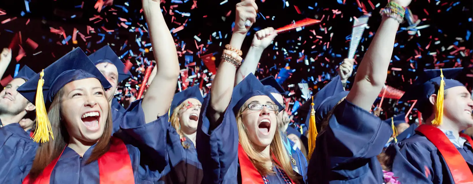 University of Arizona graduates cheering while confetti falls at graduation