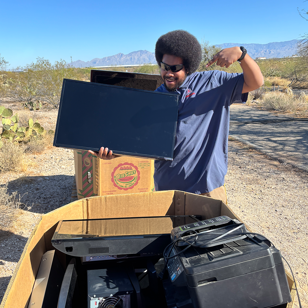 Tech Park employee standing with donated technology goods