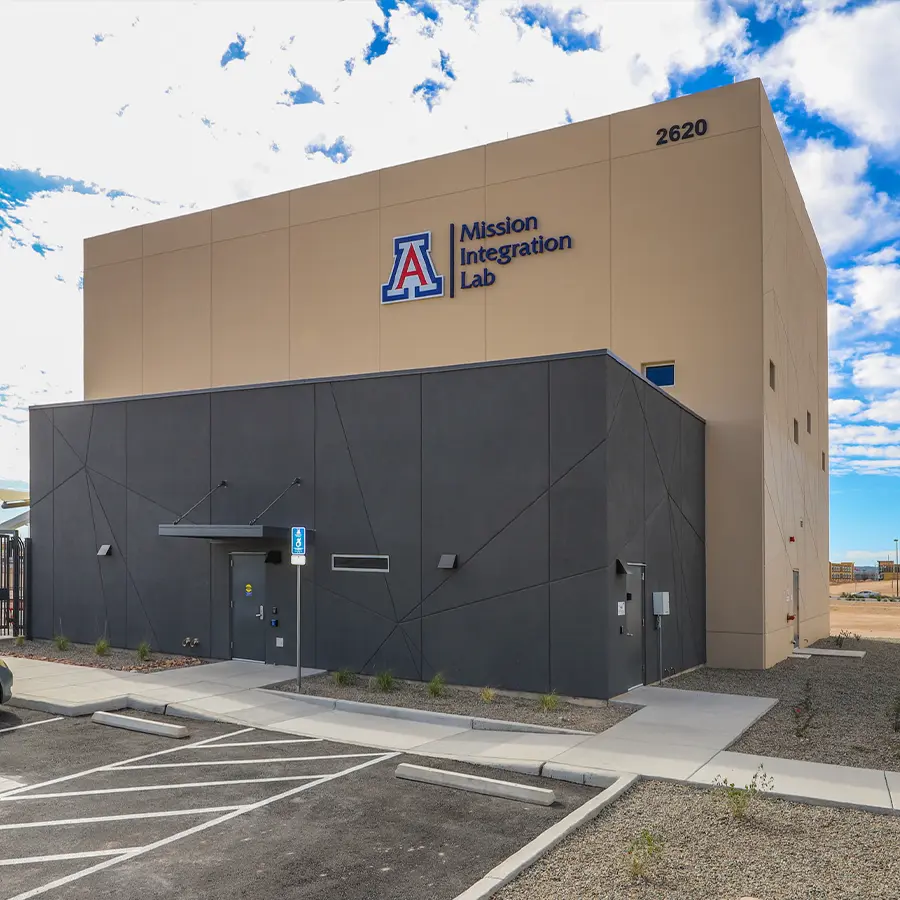 Building with tan and grey outside walls and sign "Mission Integration Lab"
