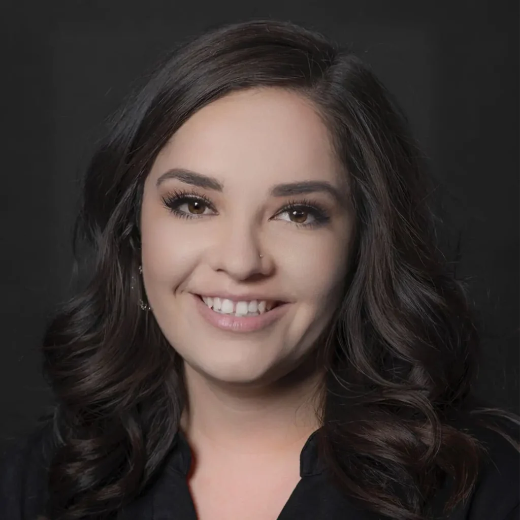 Headshot of Casey Carrillo smiling and wearing a black top.