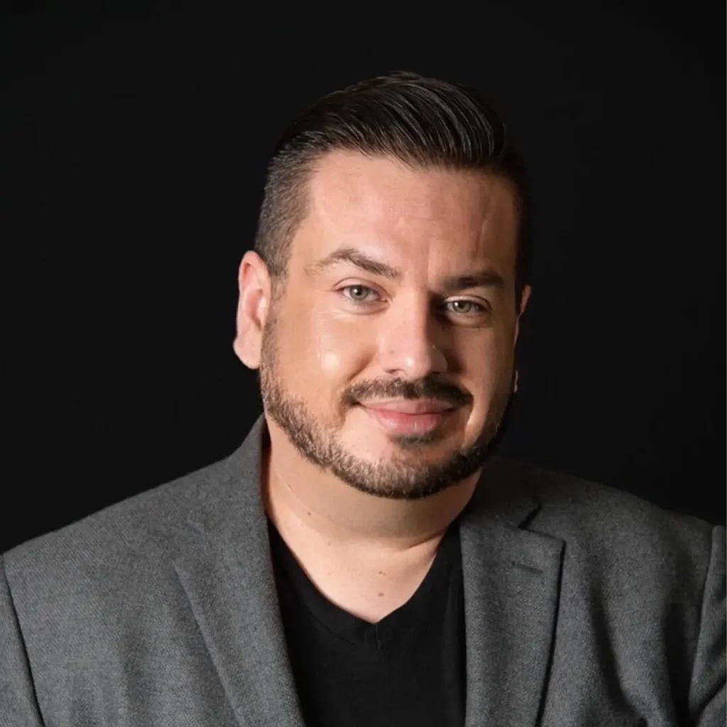 Headshot of Peter Loya wearing a grey blazer