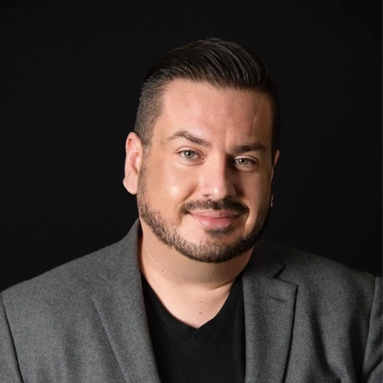 Headshot of Peter Loya wearing a grey blazer