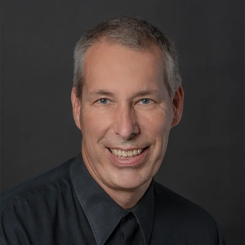 Headshot of Peter Nestler wearing a black button-down.