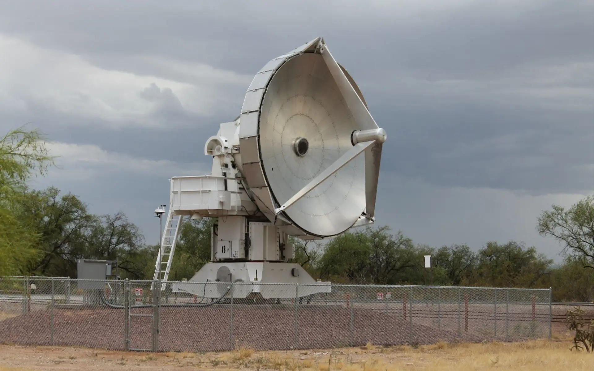 Satellite with cloudy sky in background.