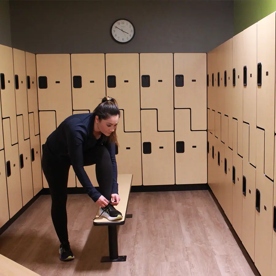 Woman adjusting shoe in a locker room.