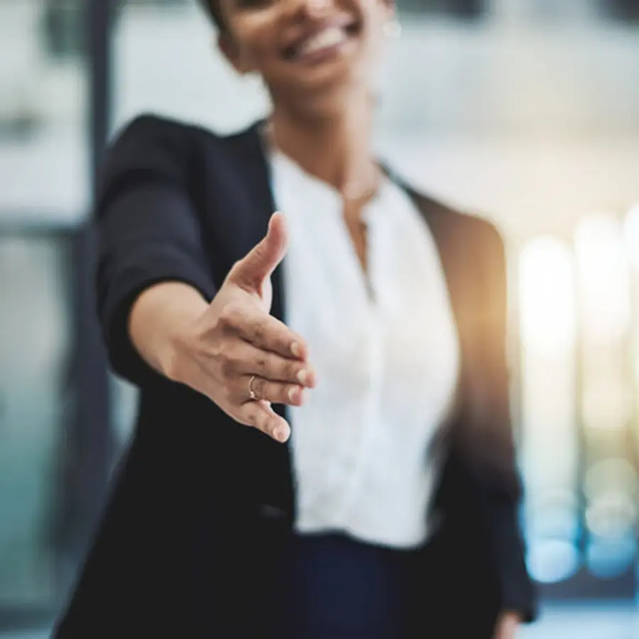 Woman reaching out hand in a professional setting.