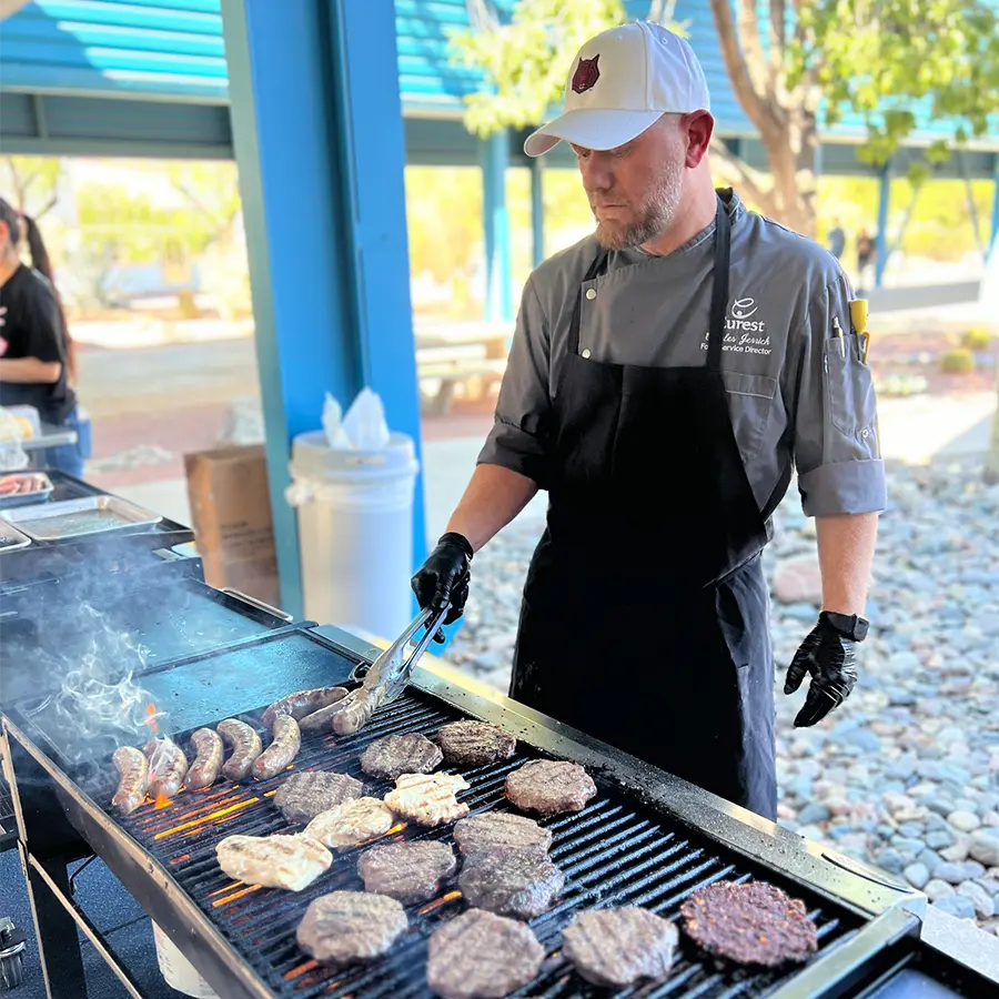 Chef grilling burgers and hotdogs outdoors