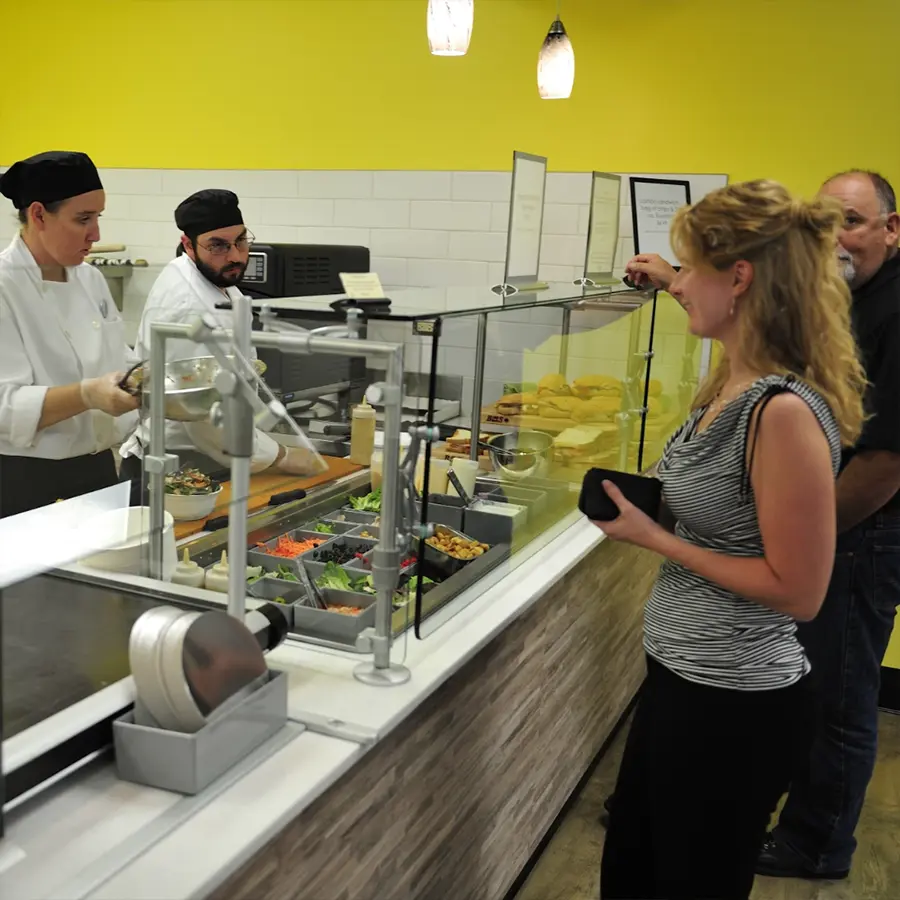 Woman ordering food in food line.