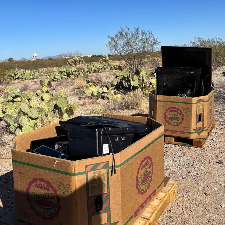 Two donation bins outside filled with electronics.