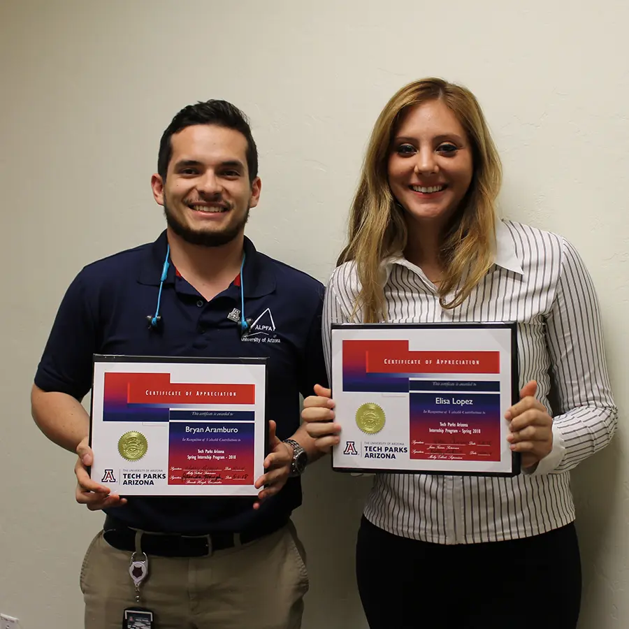 Two people smiling and holding up certifications from Tech Parks Arizona.