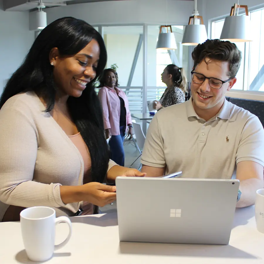 Two professionals working together and looking at a computer.
