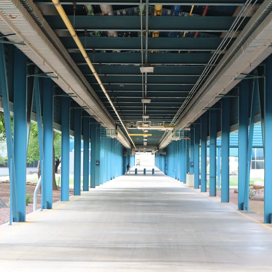 Covered walkway with exposed utilities and structural beams at UA Tech Park in Tucson.